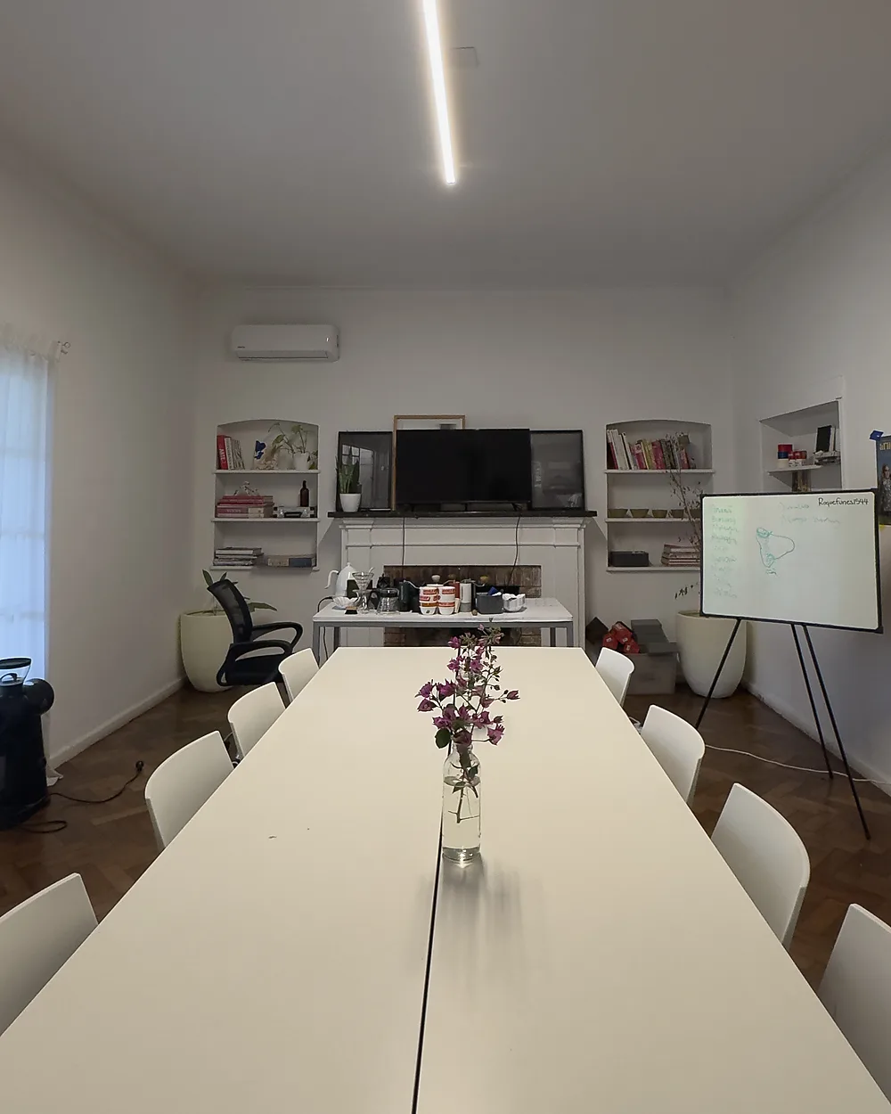 Sala grande de reuniones de Lätt, con TV, pizarra y estanterías